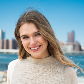 blonde girl on the background of the city with a perfect smile