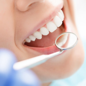 checking the condition of the teeth with a dental mirror