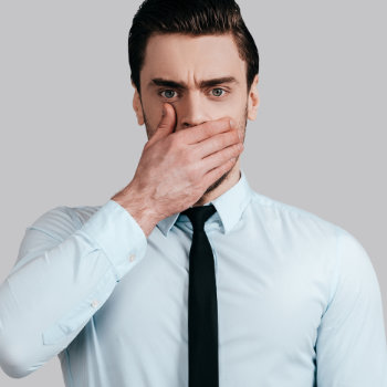 handsome businessman covers his mouth with his hand