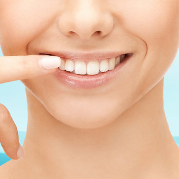 woman pointing to her healthy smile