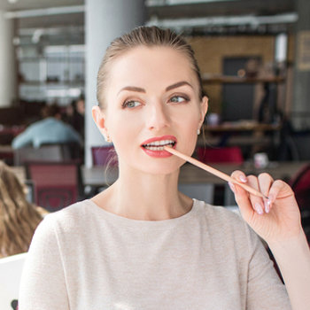 young woman pensively biting a pencil