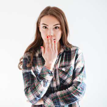 girl covers her mouth with her hand